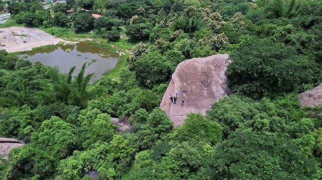 Aerial view of adventurers rock climbing and rappelling on Ramanagara Hill&rsquo;s large rock formation