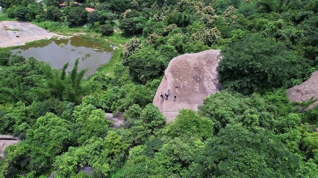Aerial view of adventurers rock climbing and rappelling on Ramanagara Hill&rsquo;s large rock formation