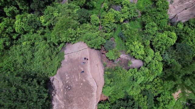 Aerial view of adventurers rock climbing and rappelling on Ramanagara Hill&rsquo;s large rock formation