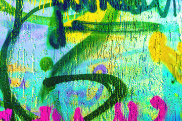 Bright graffiti wall with yellow, green, pink, blue spray paint. Urban street art, 90s, Y2K culture, grungy texture, paint mural. Poster background texture, creative banner, street visual. © Aleksandra Konoplya