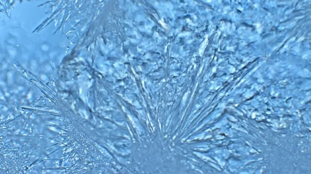 Frozen crystal formations on ice surface with intricate patterns and frosty textures captured in a close-up high-definition view