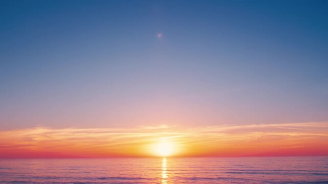 Evening sky glows in beautiful crimson hues above the ocean. Bright orange clouds hover over the horizon, beauty of a sea sunset near the rocky shore. A picturesque sunset with the calm water surface.
