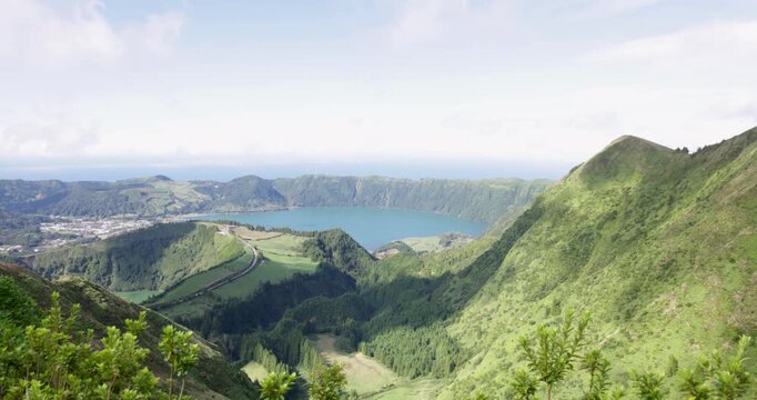 A beautiful view of a volcanic lake in a crater surrounded by mountains at Sete Cidades.