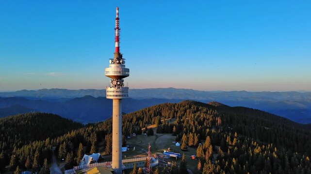Tower Snezhana on peak of Snezhana covered with spruce forests in Rhodope mountains