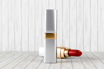 A silver and gold lipstick case stands upright on a white wooden surface with a red lipstick lying beside it © cozzdesign