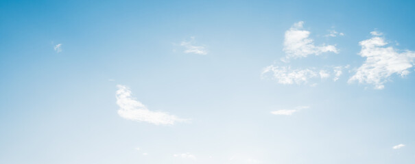 the sky is clear blue with fluffy white clouds, the sky is very bright, and the sun shines.