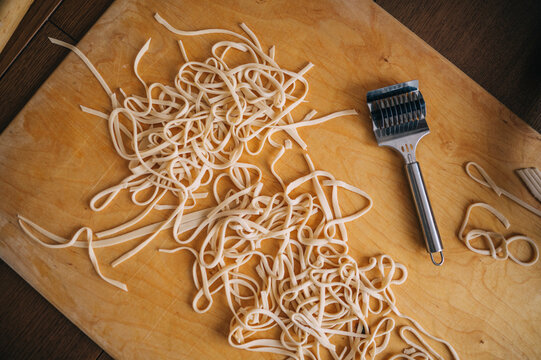 Homemade noodle dough being prepared on kitchen cutting board
