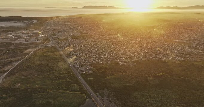 Cape Town South Africa Aerial v106 flyover Baden Powell Dr capturing sunset landscape of Khayelitsha township, with crowded slums of clustered shacks - Shot with Mavic 3 Pro Cine - Jan 11th 2024