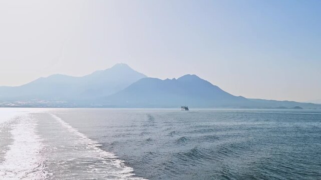 有明海を航行するフェリーからの景色 遠ざかる雲仙普賢岳と航跡
「静かな海に残る白い道。島原の山々を背に、熊本へと進む船上のひととき」
A view from a ferry sailing across the Ariake Sea: Mount Unzen and its wake receding into the distance.