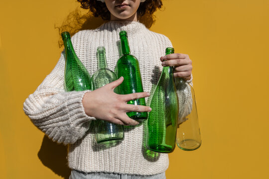 Child holding glass bottles showing sustainability and recycling