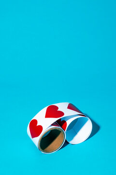 Heart sticker roll on vibrant blue background with playful romantic motif