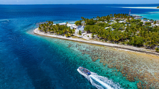 Aerial view of tourist boat cruising around Amaru lagoon Tuamotu islands