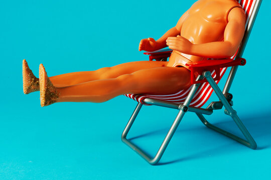 Plastic figure with sandy soles in red striped chair fantasy holiday scene