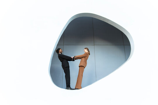 Business professionals demonstrate teamwork in abstract Barcelona architecture