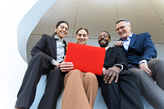 Business team smiling with red laptop in Barcelona office