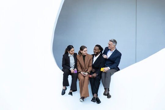 Business team collaborating and conversing in modern minimalist setting