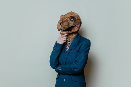 Businesswoman in dinosaur mask thinking metaphor for outdated worker