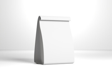 A white, empty, folded paper bag with a rectangular bottom and a curved top standing upright on a plain white surface with subtle shadows © cozzdesign
