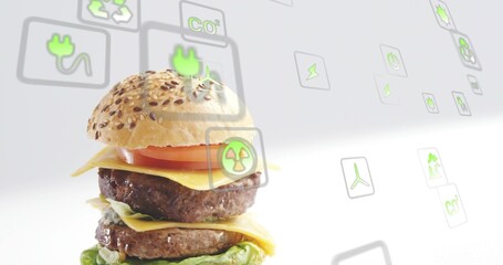 Displaying double burger with seeded bun, beef patties on studio set with eco icons, copy space