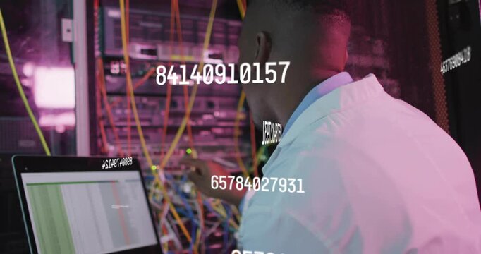 Male network tech reading laptop data, adjusting yellow patch cables, numeric overlay guiding fixes