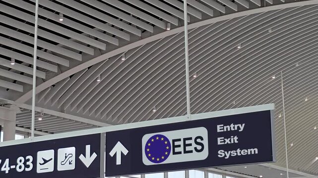 Information panel with the European Union logo and the new EES Entry Exit System sign hanging from the ceiling inside a modern international airport terminal, a crucial border control innovation