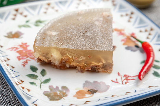 Closeup of traditional Russian holodets (aspic jelly meat) served with mustard and green onion.