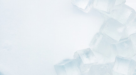Crystal clear ice cubes on a natural snowy surface. light blue tones background. © stone36