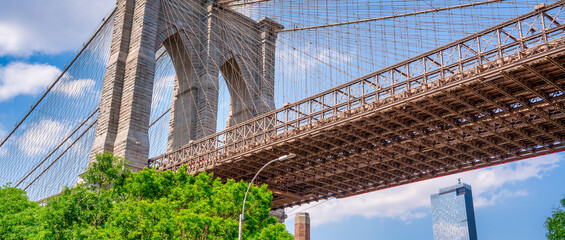 Fototapeta premium Iconic Brooklyn Bridge seen from Brooklyn Bridge Park during bright summer daylight, New York City