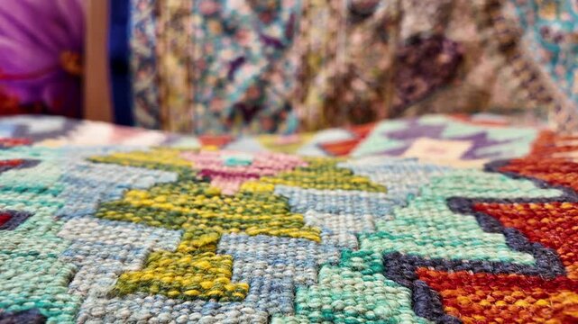 A close-up view of colorful woven carpet with intricate patterns and textures, showcasing traditional craftsmanship and vibrant designs
