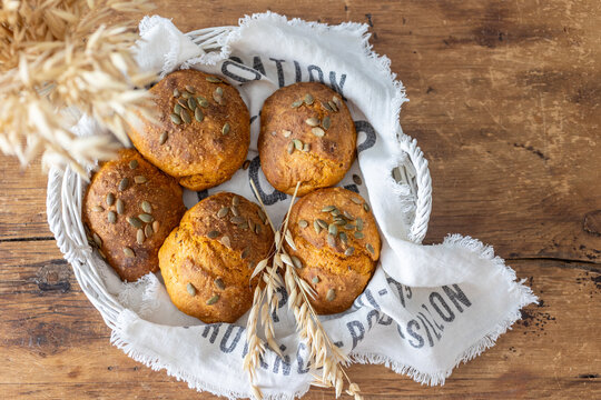 Carrot bread rolls with pumpkin seeds in a rustic basket