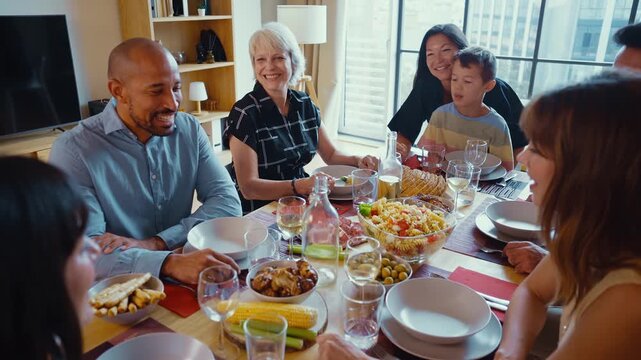 Family and friends reunion at home. Diverse family gathering enjoying dinner at home	
