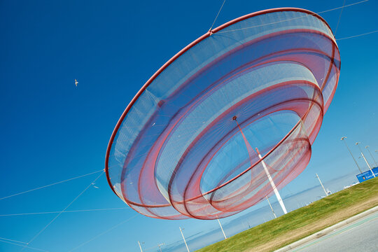 The "She Changes" net sculpture (Anemona) by Janet Echelman suspended against a clear blue sky in Matosinhos, Porto, Portugal, Europe.