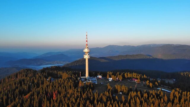 Tower Snezhana on peak of Snezhana covered with spruce forests in Rhodope mountains
