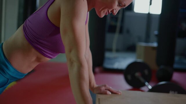 Intense Workout Routine: A Focused Female Athlete Engages in Strength Training Through Formidable Push-Ups in a Modern Gym Environment