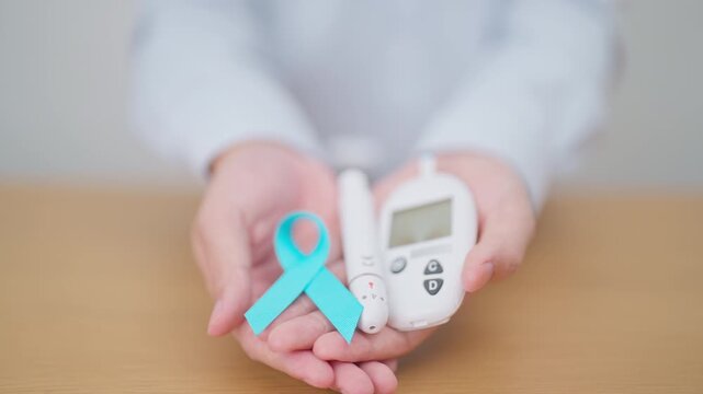 Hand show Blue Ribbon and digital blood glucose meter with lancet pen. high blood sugar level, November World Diabetes Day, Awareness month, Glycemia,, Hyperglycemia and insulin testing and checking
