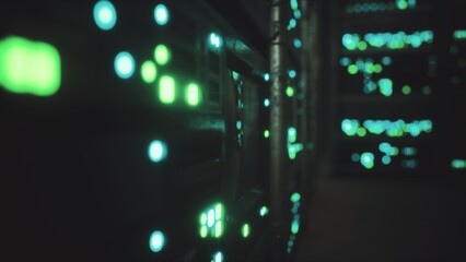 Obraz premium Amidst the shadows, bright green and blue lights illuminate rows of servers in a data center. These glowing indicators signify active processes and data flow, showcasing modern technology at work.