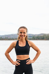 Fototapeta premium Fitness woman relaxing outdoors near river after workout