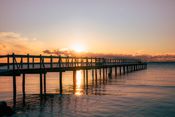 Baltic Sea pier at sunset with golden light reflecting on calm water