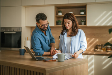 Couple planning home finances managing budget in kitchen © Miljan Živković