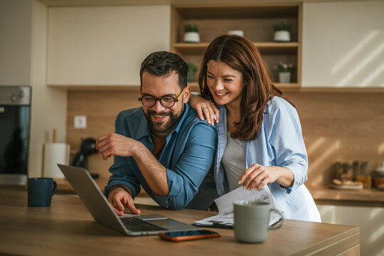 Couple planning home finances managing budget in kitchen