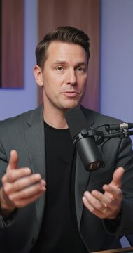 Man speaking into microphone indoors for business or education