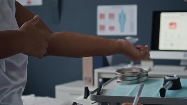 B roll shot of dermatologist listening and writing on clipboard as Black female patient demonstrating inner upper arm skin during medical consultation in clinic office