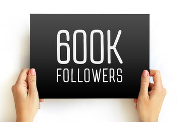 600K Followers text on card held by hands. Minimal milestone banner for social media growth...