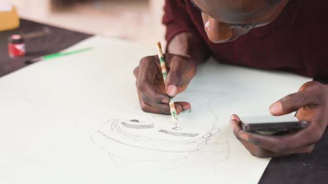 Black artist sketching portrait on paper, closeup hands holding pencil and smartphone reference, dotted outline forming face under warm studio light, focused intimate mood and textured graphite lines.