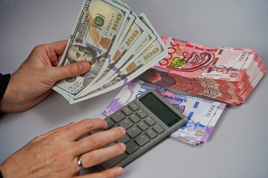 100 dollar bills and tenge banknotes in denominations of 5,000 and 10,000 on a paper background. Exchange rate, deposits, currency storage
