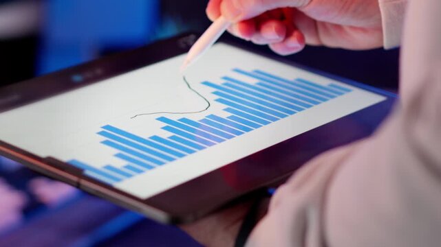 Tablet stylus bar chart financial analytics closeup. Blue histogram columns upward trend line performance evaluation revenue growth statistics data visualization corporate strategy digital dashboard m