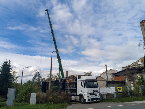 Polska, Ostrowiec Świętokrzyski, 6 października 2025, 12:34. Mercedes Actros podczas demontażu masztu telefonii kom&oacute;rkowej. Wok&oacute;ł gęsta roślinność, a w tle widoczne są stare, częściowo zniszczone budy
