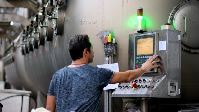 Professional industrial footage reflecting human labor, work discipline and technical responsibility. Worker operating a control panel on a textile production line.
