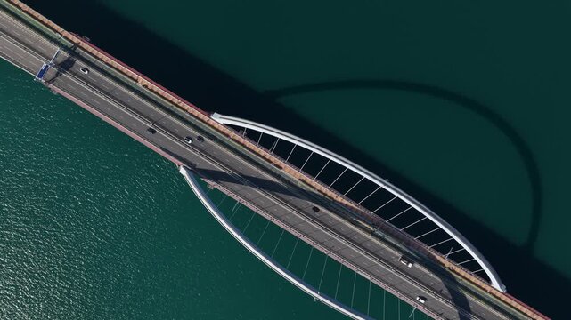 tunning aerial drone perspective of the Tseung Kwan O Cross Bay Link Bridge in Hong Kong, showcasing modern architecture, coastal transport infrastructure, and urban connectivity on a clear sunny day.
