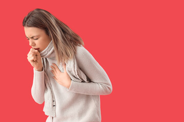 Ill young woman coughing on red background